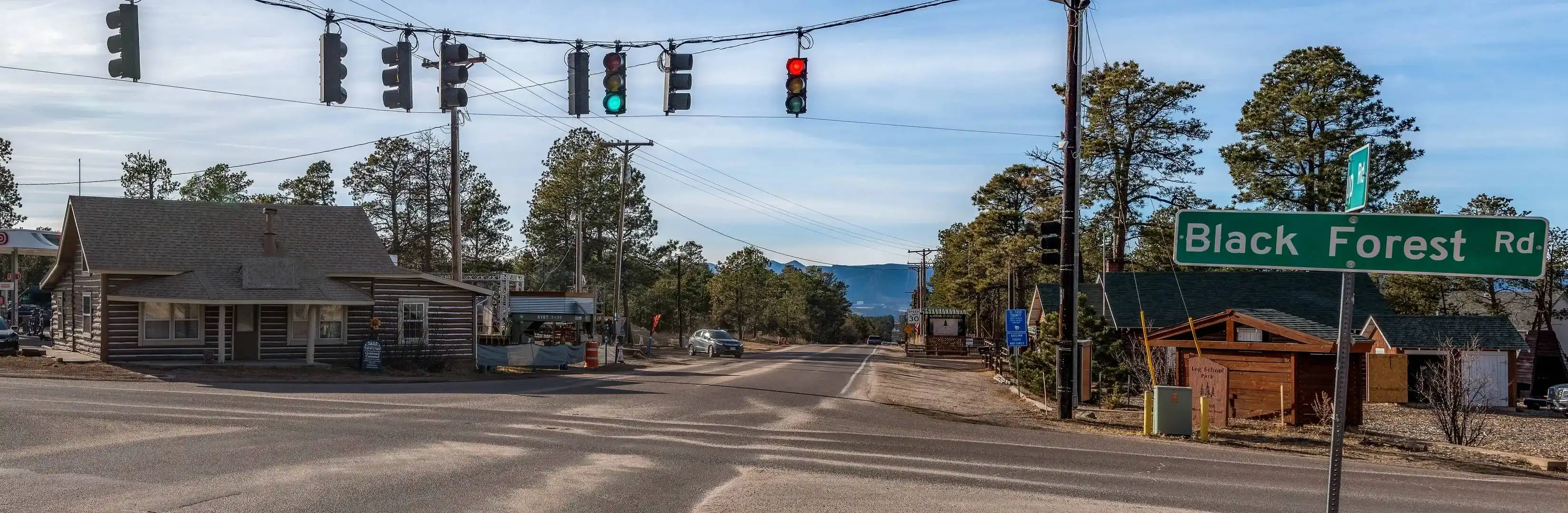 Professional siding replacement and repair services in Black Forest, CO, shown at the intersection of Black Forest Road with local residential buildings