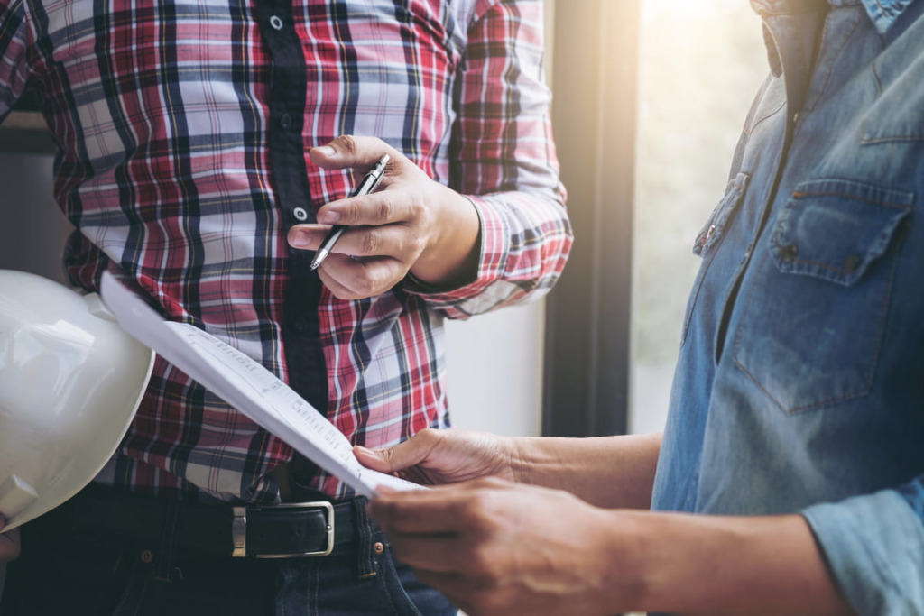 Contractor and homeowner reviewing a project estimate and documents together before signing a contract